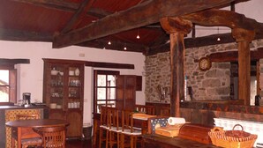 Un coin repas rustique, avec des meubles en bois, un mur en pierre et un plafond en bois.