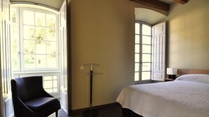 Ein Hotelzimmer mit einem Bett, einem Sessel und einer Stehlampe.