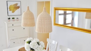 A dining area with a white table, white chairs, and two hanging pendant lights. - Stone house with charm (Medulin)