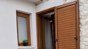 Two wooden lounge chairs with white cushions, positioned on a tiled patio area. - Stone house with charm (Medulin)