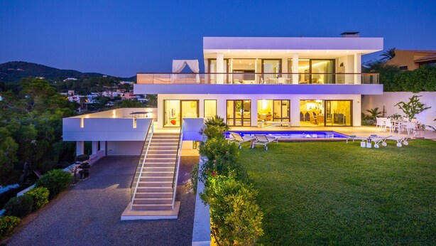 Une maison moderne à deux étages, dotée d’une piscine, d’un espace salon extérieur abrité et d’une pelouse bien entretenue.