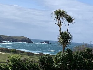 Un paysage côtier offrant une vue sur l’océan et de hautes falaises rocheuses.