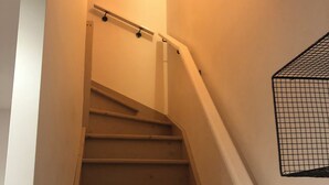 A staircase with a handrail and a wall-mounted security camera.