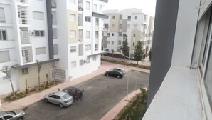 A residential street with modern apartment buildings, a clear sky, and parked cars. - apartment 6 person 10 minutes from the beach (agadir)