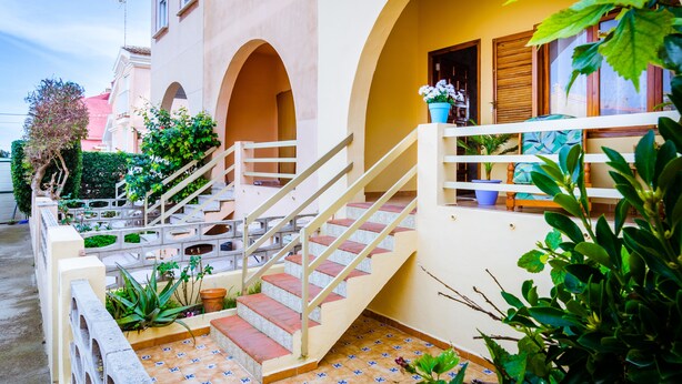 A multi-level building with a staircase, potted plants, and a balcony with a view. - Chalet on the beach Valencia Mareny Sueca Cullera (Mareni de Barraquetes Sueca)