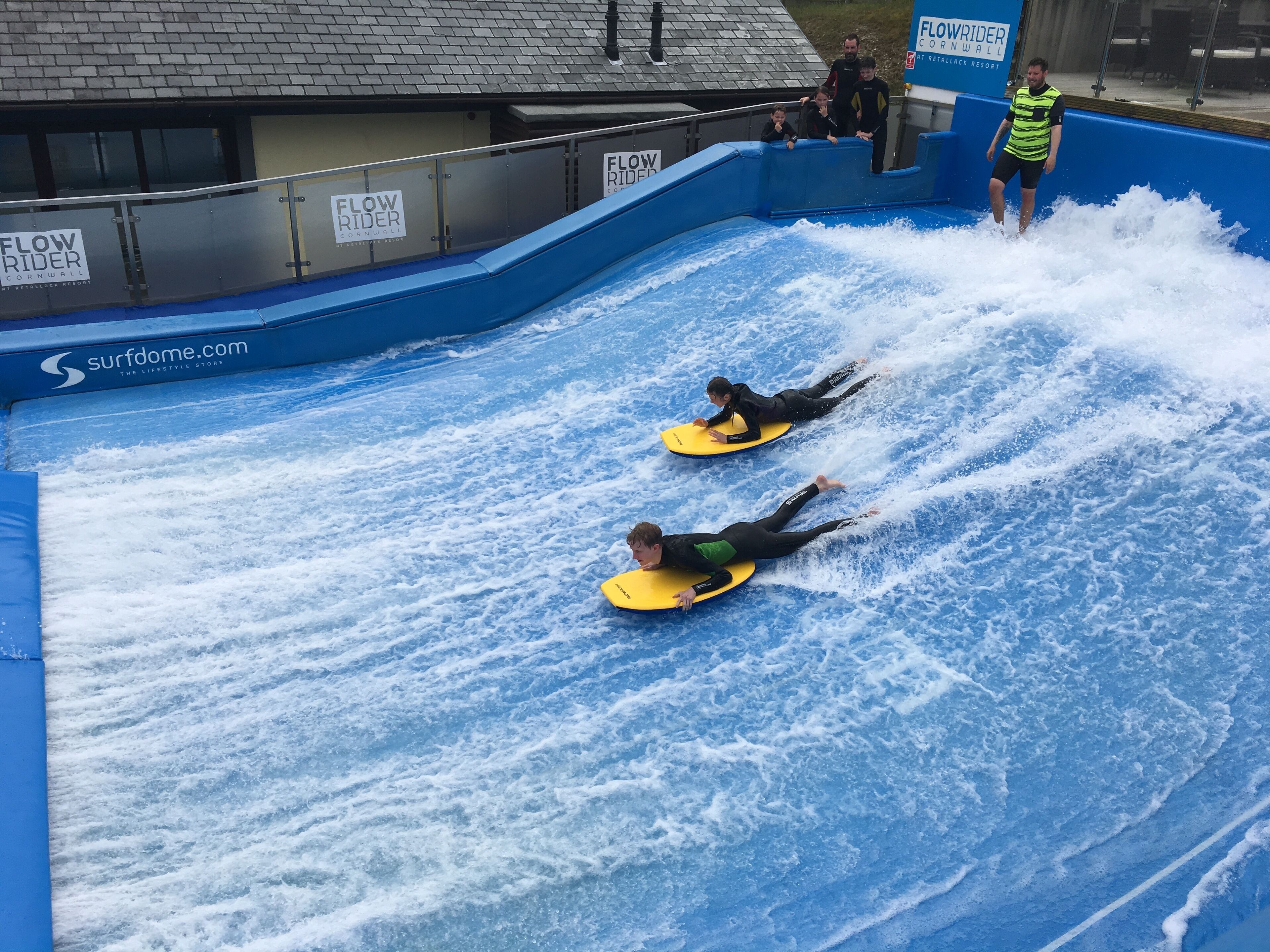 A water slide at a facility with blue walls and a roof.