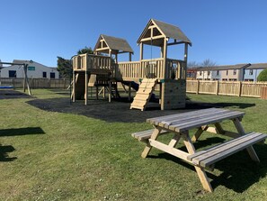 Kids can climb, slide, and play in this playground with a shelter and picnic area nearby.