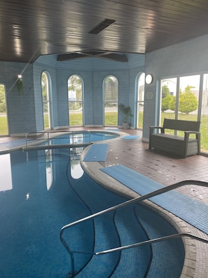 Relax by the pool with a view of the surrounding landscape through large arched windows.