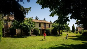 A house with a tiled roof, a front porch, and a well-maintained lawn. - Casa Corral for 4 people (Lladurs)