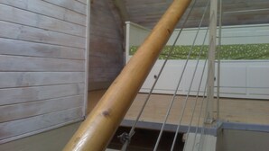 A wooden staircase with a metal railing, leading to a room with a green patterned wall. - the barn of Paul, seasonal rental in the peninsula of Rhuys (Le Hézo)