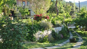 Un camino de piedra que lleva a una casa con jardín.