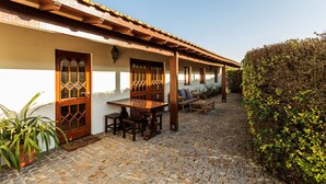 Un cortile con pavimento in pietra, arredi in legno e una pergola.