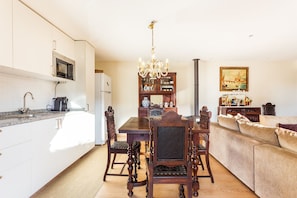 Una cocina moderna con comedor, muebles de madera y una araña.
