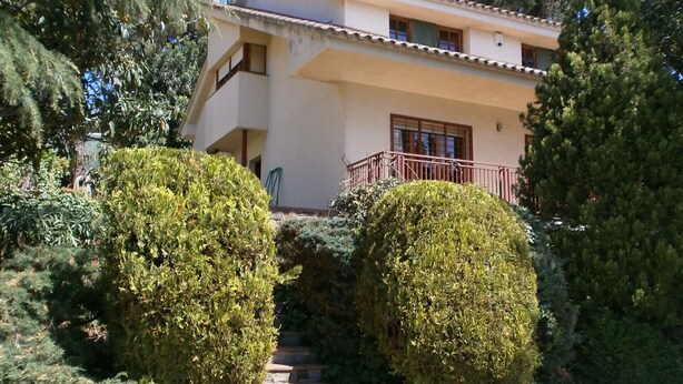 Un edificio di due piani con una scala in pietra che conduce a un balcone.