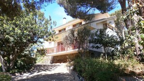 Un edificio a due piani con un vialetto in pietra che conduce a un ingresso chiuso da cancello.