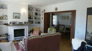 Un soggiorno con camino, un divano e un'area da pranzo.