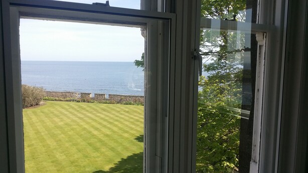 A view of a well-maintained lawn and a stone wall leading to the sea. - Harbour View Apartment with panoramic sea views in Crail (Crail)