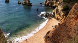 A coastal beach with rocky cliffs and clear blue waters. - Exclusive Luxury Apartment, Garden Backing On First Green (Lagos)