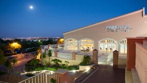 A hotel named 'Essential' with a well-lit entrance, a covered outdoor area, and a view of the cityscape in the background. - Exclusive Luxury Apartment, Garden Backing On First Green (Lagos)