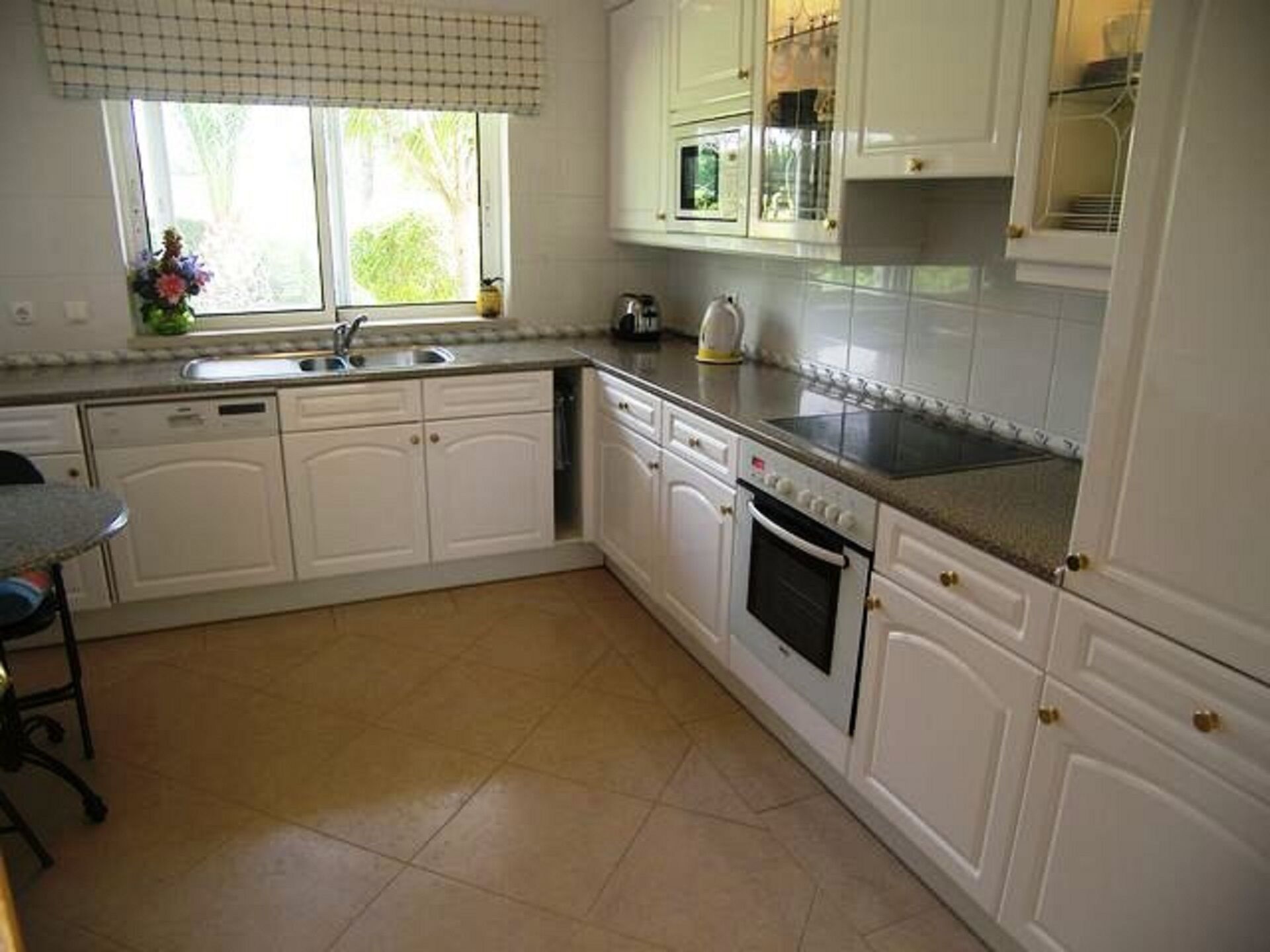A kitchen with white cabinets, a stove, and a sink.