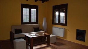 Una sala de estar con sofá, mesa de centro y chimenea.