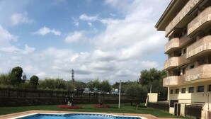 A rectangular swimming pool with a tiled deck in the foreground. - Boadella Apartment (Lloret de Mar)