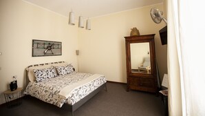A bedroom with a bed, a mirror, a lamp, and a painting on the wall. - La Darsena di Riva Grande - Comballi (montrasio)