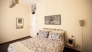 A bedroom with a bed, a bedside table with a lamp, and a wall-mounted clock. - La Darsena di Riva Grande - Comballi (montrasio)