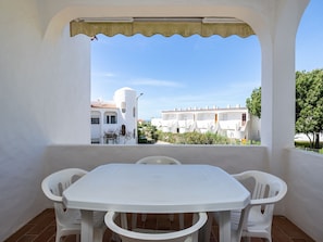 Enjoy a peaceful balcony with a table and chairs overlooking a residential area.