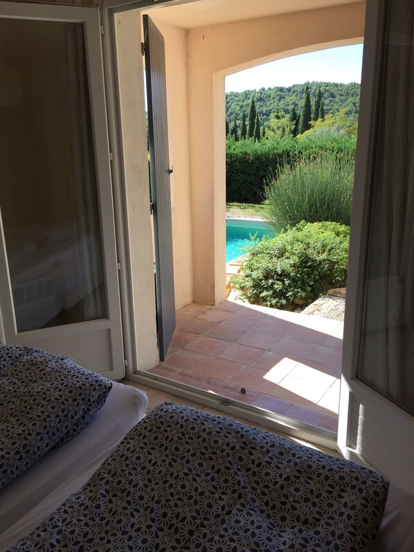 An open doorway leading to a patio with a pool, surrounded by greenery and hills. - High standard Villa, Great view, Private pool, Short walk to the Village (Seillans)