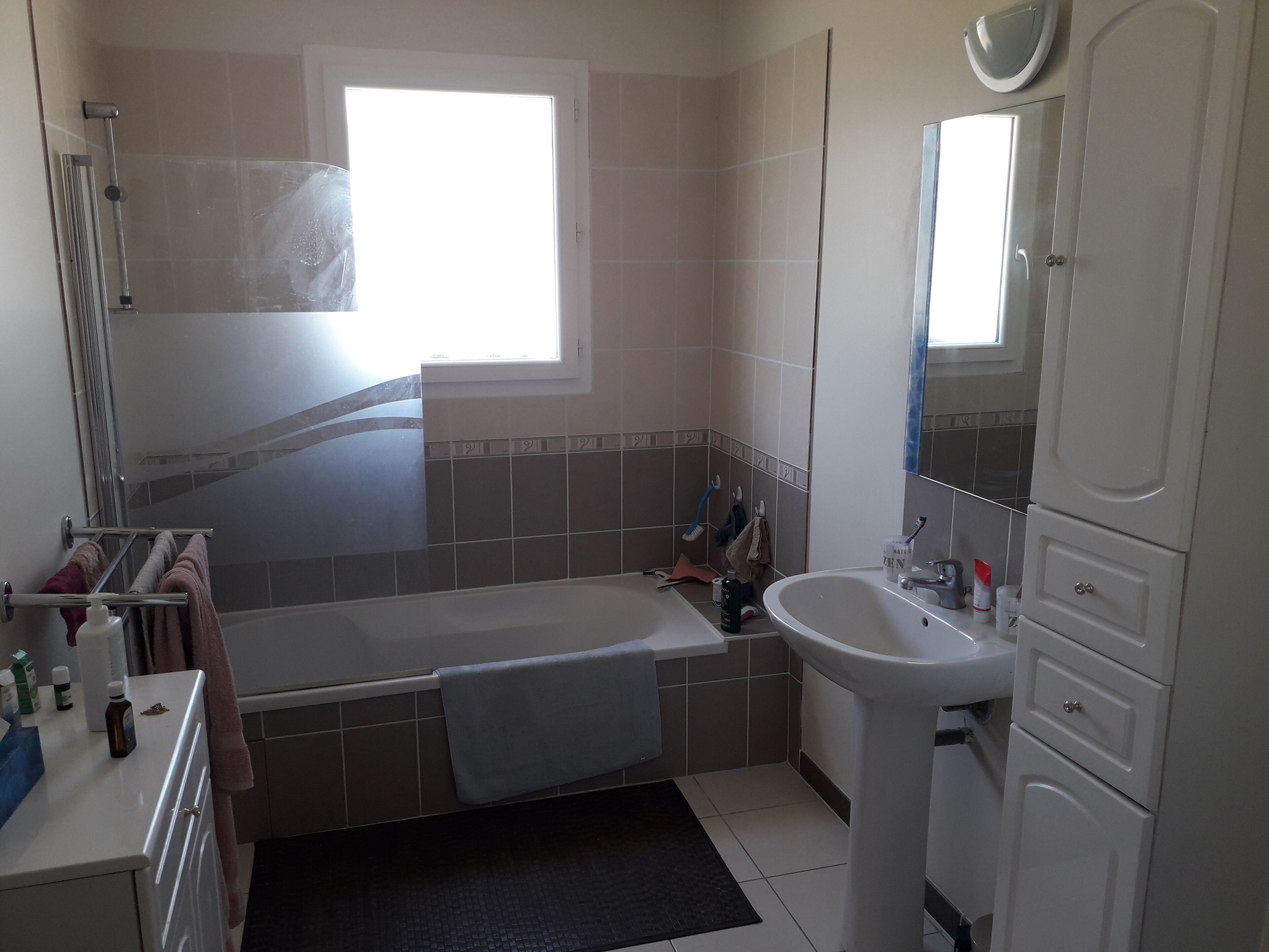 A bathroom with a bathtub, a sink, and a mirror.