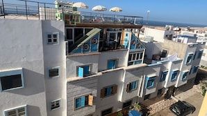 A multi-story residential building with balconies, a rooftop terrace, and a view of the sea. - Charming 2 bedroom  Penthouse with nautical decor (Aradir Provence)