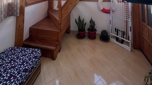 A wooden interior with a staircase, potted plants, and a television. - Charming 2 bedroom  Penthouse with nautical decor (Aradir Provence)