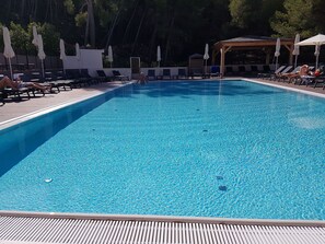Una piscina al aire libre, una piscina climatizada