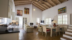 Un espacio de estar amplio con chimenea, una mesa de comedor y asientos cómodos.