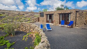 Un bâtiment en pierre avec deux fauteuils et une porte.