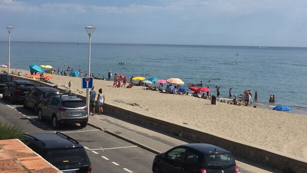 A beach with parked cars and people enjoying the seaside. - Rents T3 - Leucate beach - Ground floor - Beachfront (Leucate)