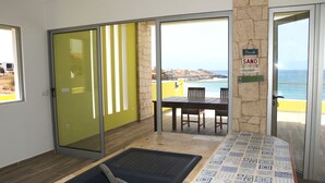 A room with a sliding glass door leading to a balcony with a view of the beach and ocean. - Pretty villa on the island of Maio Cape Verde with panoramic views of  Atlantic (Vila do Maio)