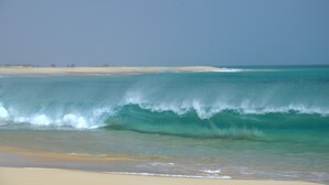 A beach with waves crashing onto the shore and a clear sky. - Pretty villa on the island of Maio Cape Verde with panoramic views of  Atlantic (Vila do Maio)