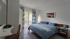 Ein Schlafzimmer mit einem Bett, einem Schreibtisch und einem Stuhl.