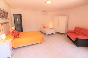 Une chambre à coucher comprenant un lit, une table de chevet, une chaise, une armoire et un banc.