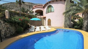 A swimming pool with lounge chairs and a stone wall. - MARYVILLA0231-Wifi y Parking Gratis-Cerca Playa (Calpe)