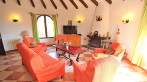 A living room with orange sofas, a television, a fireplace, and a checkered floor. - MARYVILLA0231-Wifi y Parking Gratis-Cerca Playa (Calpe)