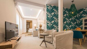 A modern living room with a flat-screen TV, beige sofas, a coffee table, and a dining area with a table and chairs. - WIDE AND COMFORTABLE 6 PERSONS APARTMENT IN DOWNTOWN - FREE WIFI AND A / C (Sevilla)