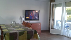 A dining area with a table covered by a patterned tablecloth, a fan, and a television on the wall. - 100m2, 3 min from the beach, very good views. Ideal for families (Salou)