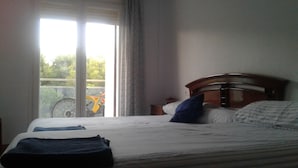 A bedroom with a bed, a window, and a bicycle outside. - 100m2, 3 min from the beach, very good views. Ideal for families (Salou)