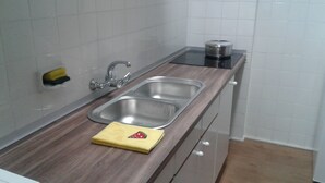 A kitchen with a stainless steel sink, a wooden countertop, and a stainless steel kettle on the stove. - 100m2, 3 min from the beach, very good views. Ideal for families (Salou)