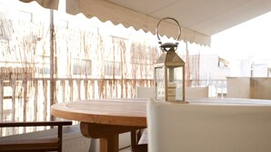 A wooden table and chairs under a canopy, with a lantern on the table. - Acropolis area next Metro & Museum (Athina)