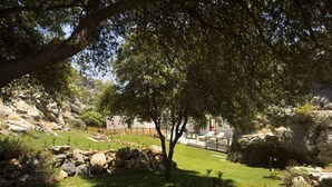 A landscaped garden with a pathway, rocks, and trees. - Villa Passithea , 3 bedroom villa plus studio with private heated pool (Lindos)