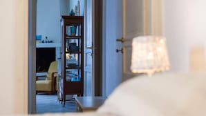 A doorway leading to a room with a wooden cabinet and a chair. - Superior Apartment Sea View (Polignano A Mare)